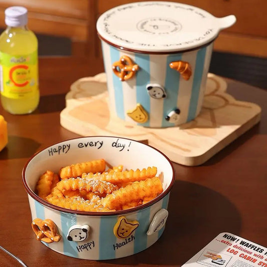 Ceramic bowl with cartoon design filled with snacks on a wooden table.