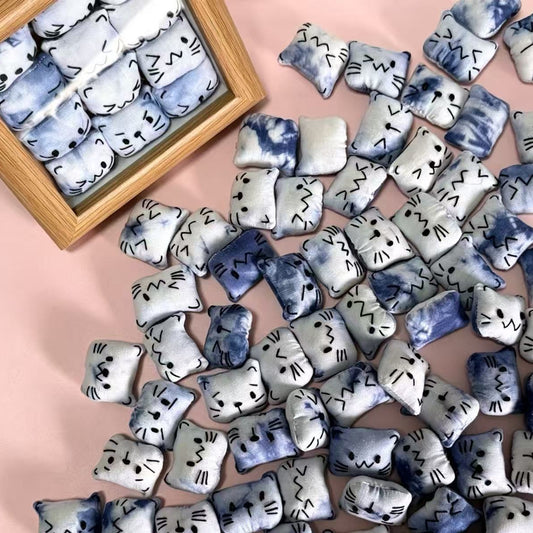 Handmade tie-dye plush cat frame — desk display lifestyle shot, 12 hand-stitched cats, MeowCeramics