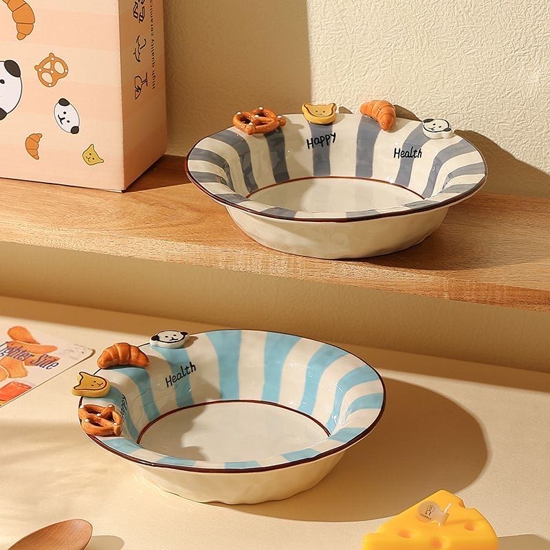 Two ceramic bowls with striped design and cartoonish animal figures on a wooden shelf.