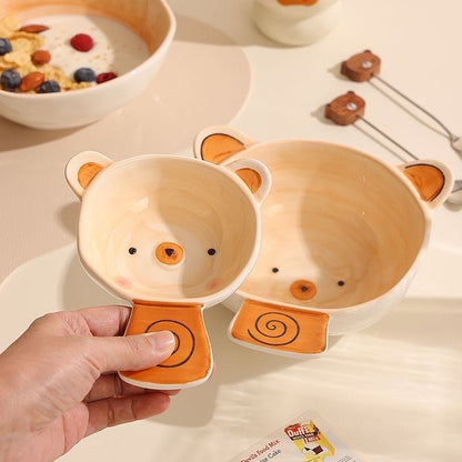 Two bear-shaped bowls with a hand holding one of them on a light background.