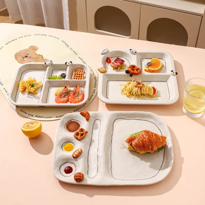 Children's divided plates with food on a light pink surface