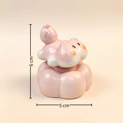 Spinning pink cat figurine assembly components — ceramic cat, base, copper bearing and adhesive, MeowCeramics
