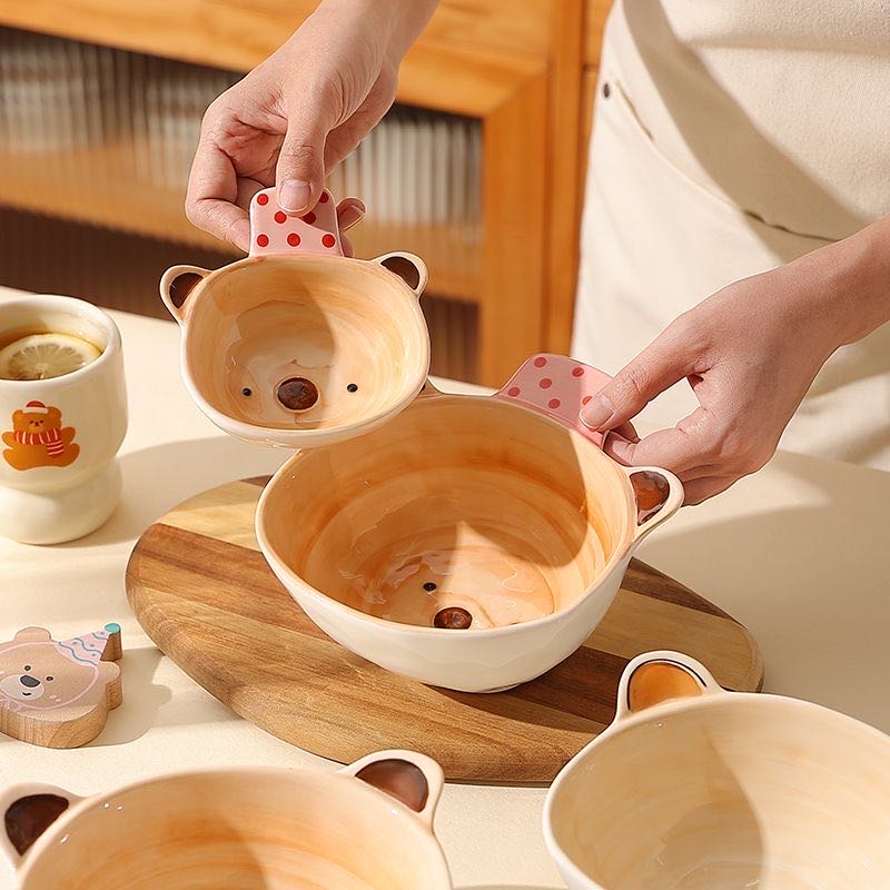 Cute animal-shaped ceramic bowls on a wooden board with a blurred background