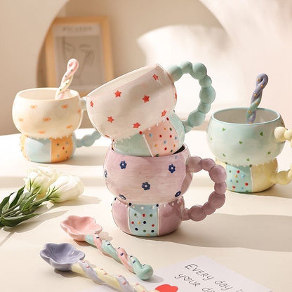 Set of colorful ceramic mugs and spoons on a light surface with a blurred background