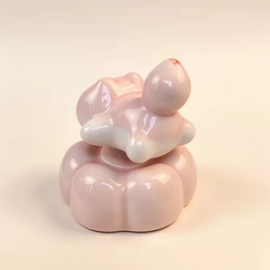 Spinning cat figurine detail — hand-sculpted pink cat with upright tail, artisan ceramic, MeowCeramics