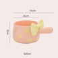 Pink cup with yellow polka dots and a yellow bow on a white background, showing measurements and capacity.