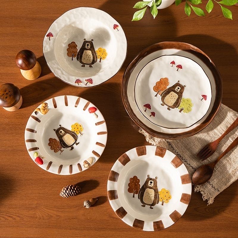 Set of ceramic plates with bear illustrations on a wooden table