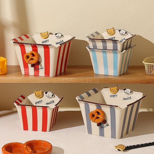 Decorative bowls with striped patterns and cartoon characters on a wooden shelf.