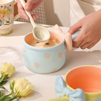 Person holding a spoon over a bowl of food on a table with a floral arrangement.