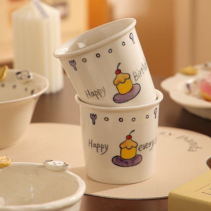 Two paper cups with cartoon designs on a wooden table.