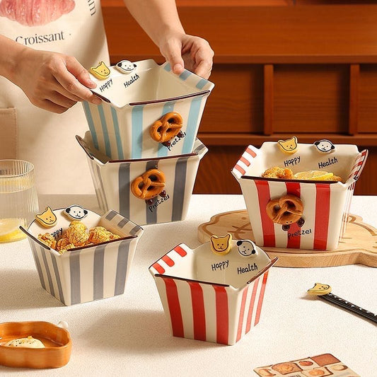 Set of small containers with striped designs and cartoon character labels on a table.
