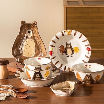 Ceramic tableware set with animal designs on a wooden surface