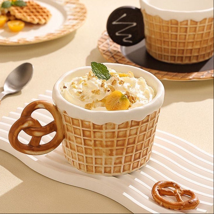 Waffle-style mug with dessert and pretzel handle on a table