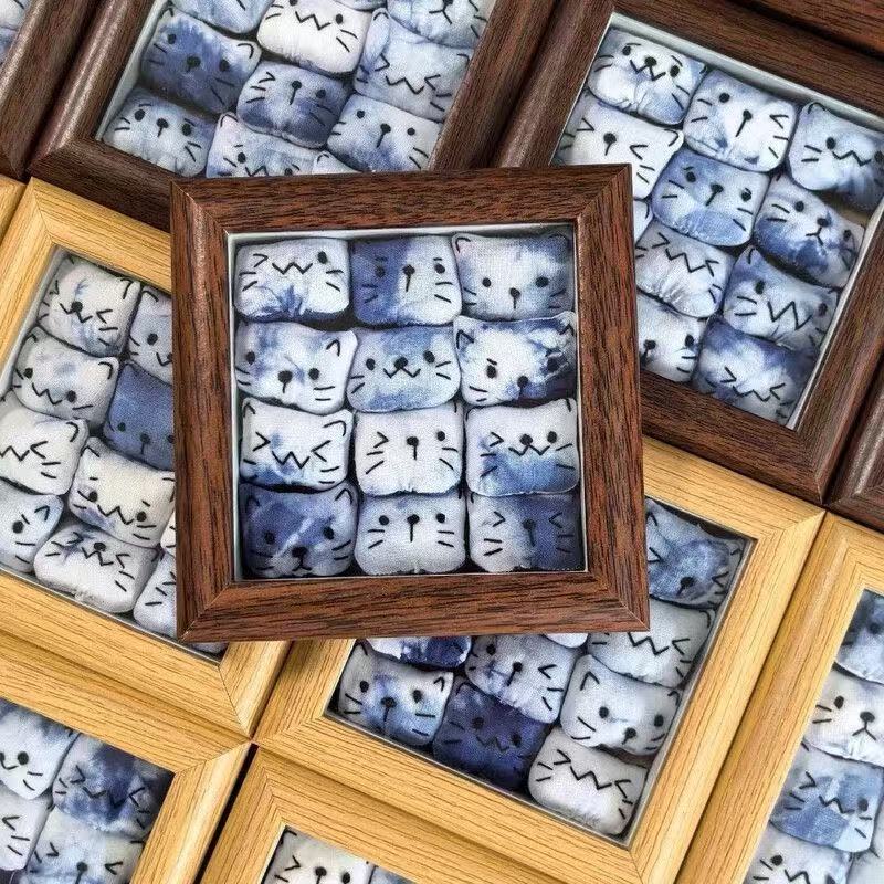 Handmade tie-dye plush cat frame — detail shot, 12 cats in frame, MeowCeramics